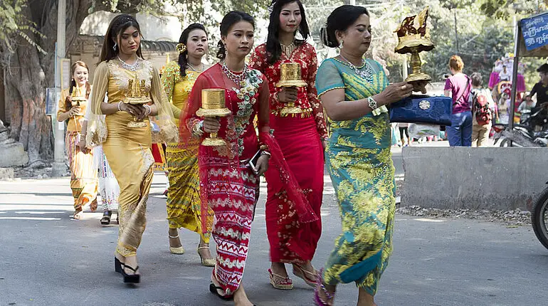 bunt gekleidete Frauen beim Novizenfest in Mandalay